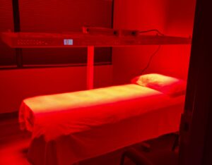 Red light therapy treatment room at White Lotus Clinic in North York — Rouge G4 photobiomodulation panel over treatment bed