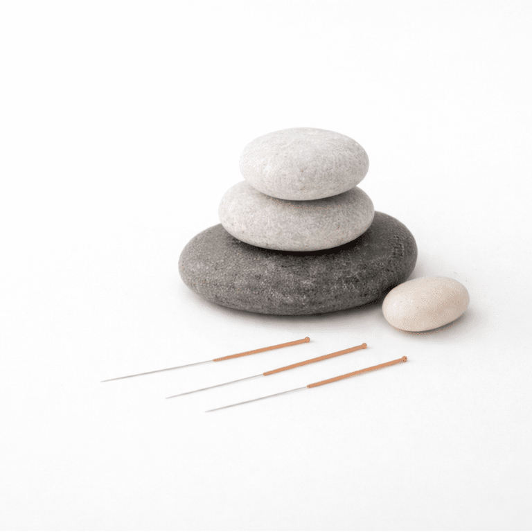 Sterile single-use acupuncture needles arranged beside smooth stones in a calm clinical setting