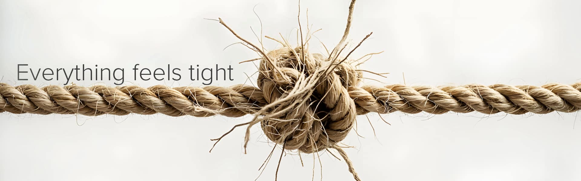 Close-up of a rope pulled tight with a knot, representing tension or stiffness